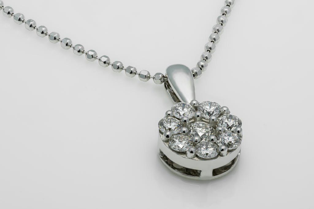 A close-up shot of a luxury diamond pendant necklace with a shiny metallic chain.